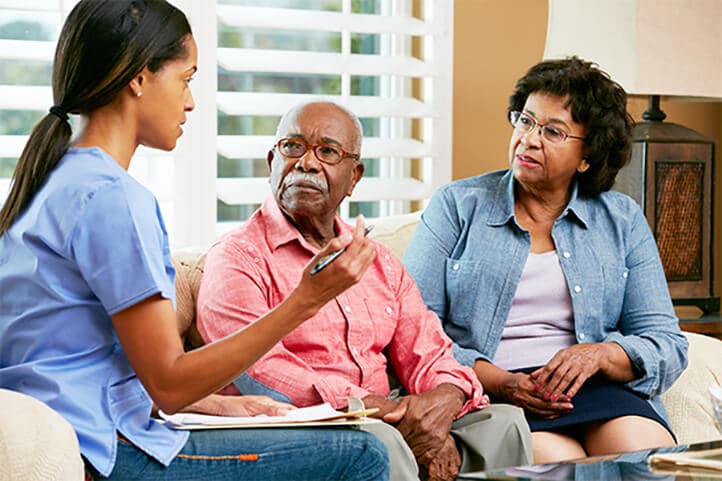 A lady having a converstaion with two seniors